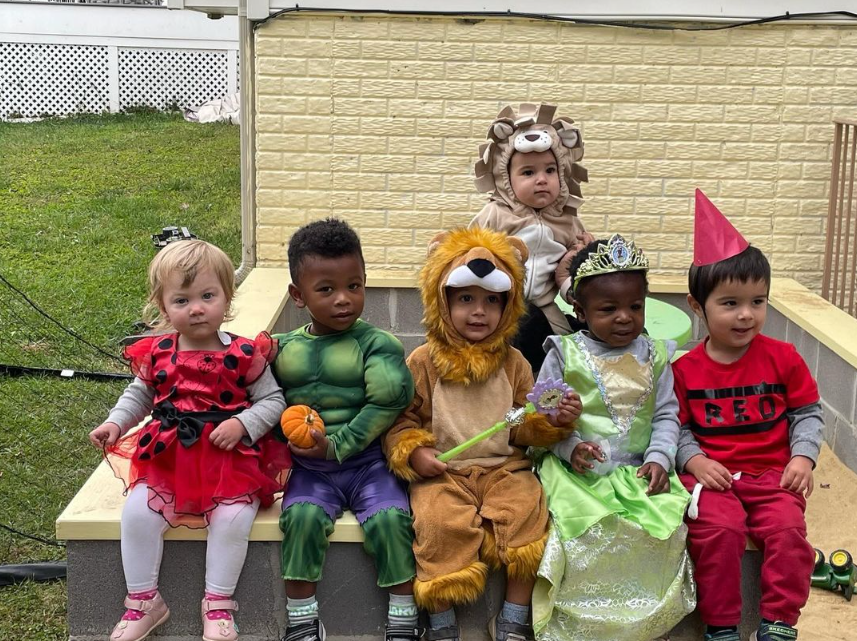 kids dressed up for Halloween sitting on a ledge