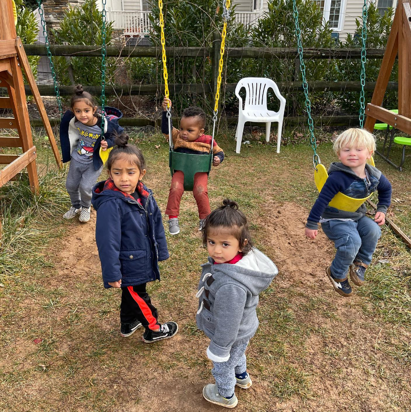 kids from busy minds daycare playing on a swing set