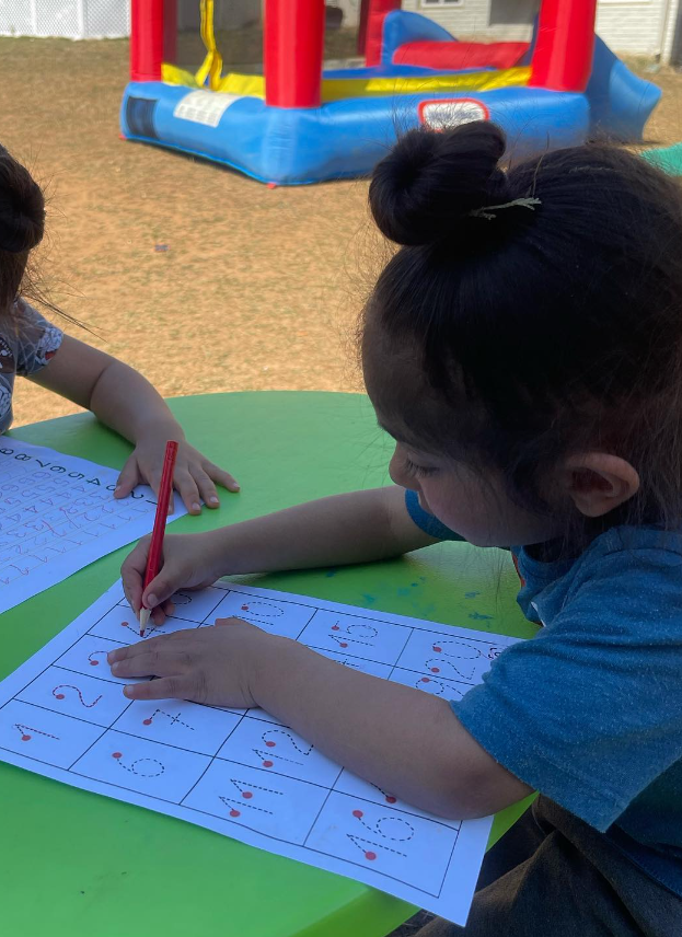 girl practicing wiring numbers on a paper template