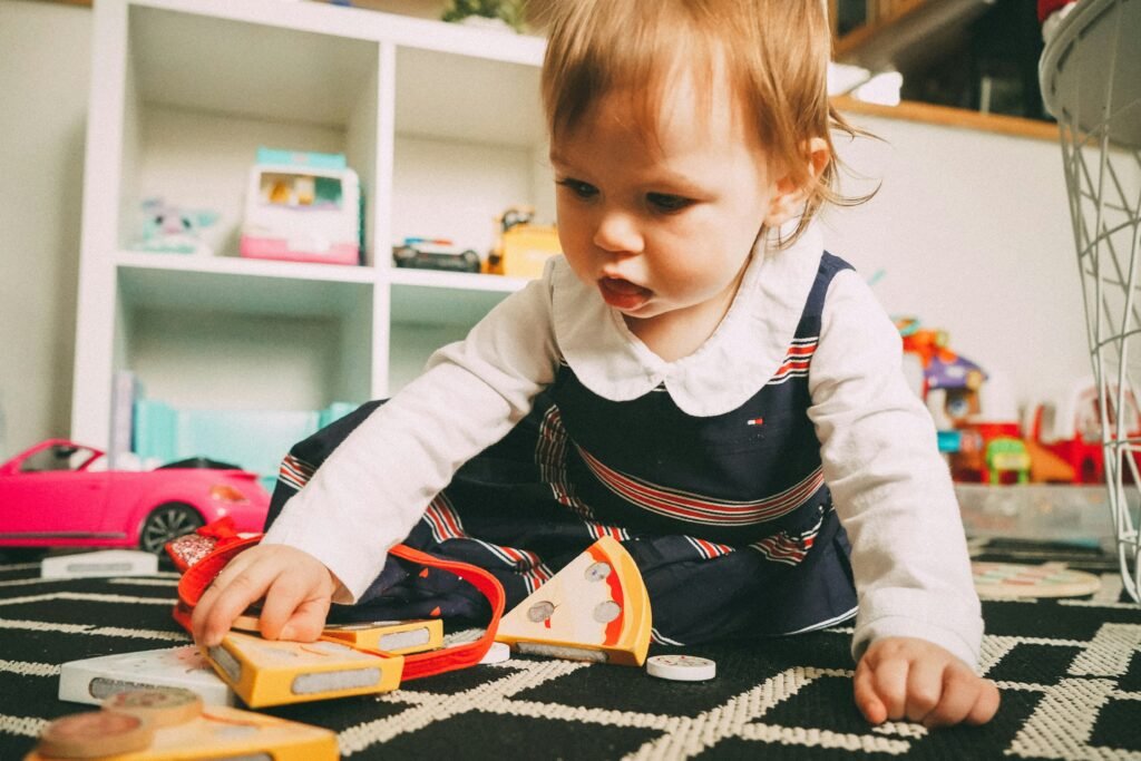 baby sitting on the ground playing with toys