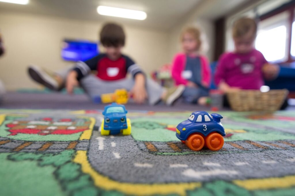 kids playing with cars on a carpet of a little town with roads